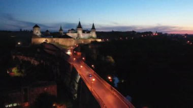 Kamenets Podolsk kalesi gece gökyüzünün arka planında. Drone görünümü