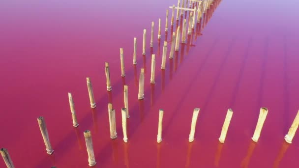 Růžové jezero a staré dřevěné stavby. Letecký pohled. — Stock video