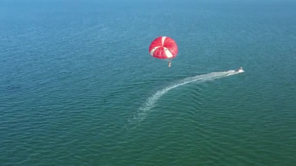 Volando con paracaídas detrás de un barco. Vista del dron. — Vídeos de Stock