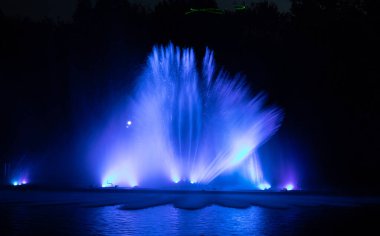 Geceleri nehirdeki renkli bir çeşmenin drone görüntüsü.