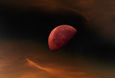 Kızıl gökyüzünün arka planında yarı aydınlık bir ay.