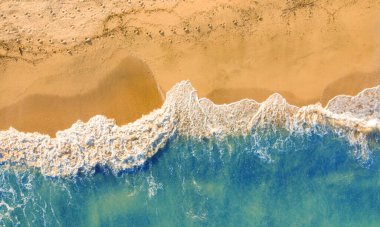 Canavarın boş kumsal manzarası, altın kum ve mavi su.