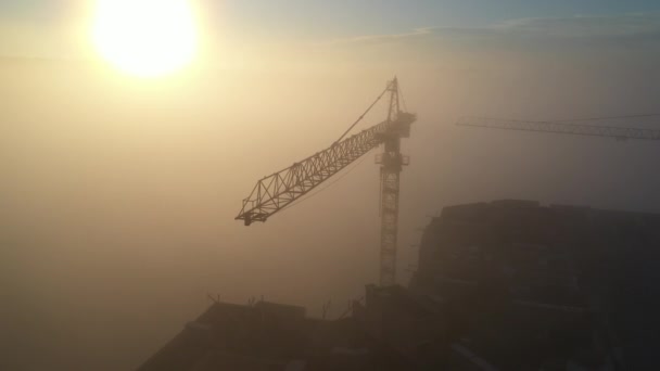 Byggkranar i gryningen på morgonen dimma. — Stockvideo