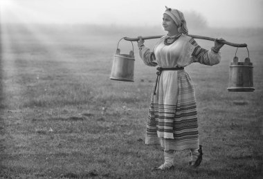 Genç ve çekici bir kadının omuzlarında nakışlı gömlek ve kovalar. Siyah ve beyaz