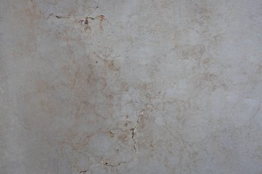 Mermer desen gri-bej, çatlaklar ve lekeler var..