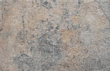 Taşın dokusu çatlaklı, lekeli kumlu-gri.