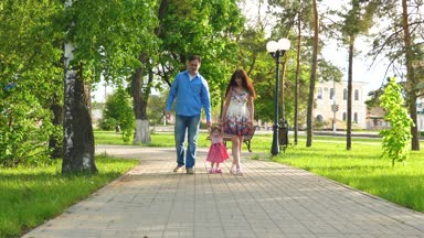 küçük bebek anne ve baba, mutlu aile yaz Park'ta yürüyordunuz yürümeyi öğrenen