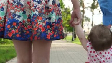 küçük bebek anne ve baba, mutlu aile yaz Park'ta yürüyordunuz yürümeyi öğrenen