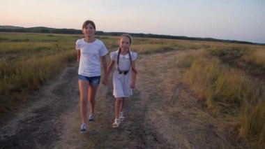 Kızlar gençler akşamları Road alanı çalıştırın. Ağır çekim.