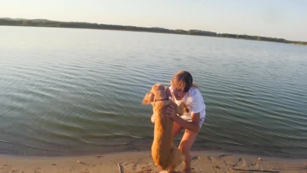Tonårig flicka tar röda hund i sina armar och leenden. Slow motion. — Stockvideo