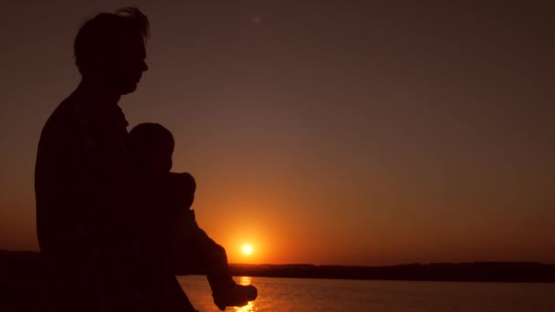 Baba bebek günbatımında kollarında tutar. Ağır çekim. — Stok video