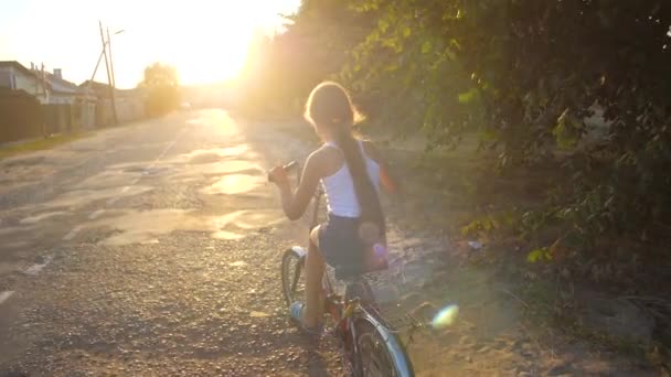 El chico va en bicicleta por la calle. Movimiento lento — Vídeos de Stock