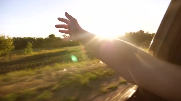 Girl waving from the car window and catches sun, slow motion — Stock Video