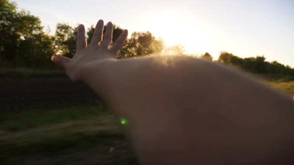 Vrouw haar hand uit de autoruit golven en vangsten van de stralen van de zon. Slow motion. — Stockvideo