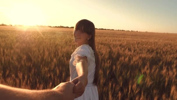 Jovem casal feliz correndo através de um campo de trigo amarelo ao pôr do sol, menina feliz rindo e sorrindo, câmera lenta — Vídeo de Stock