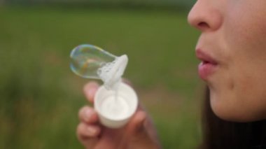 Şeffaf sabun köpüğü üfleme ve gülümseyen güzel kadın. Ağır çekim