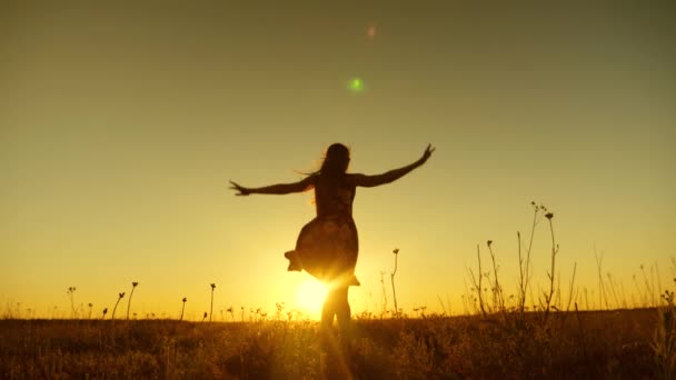 En flicka hoppar på solnedgången av golden sun. Slow motion. — Stockvideo
