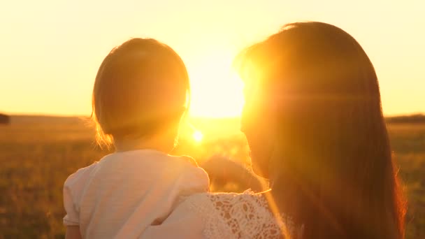 Bebé pequeno nos braços da minha mãe no zakt do sol dourado . — Vídeo de Stock