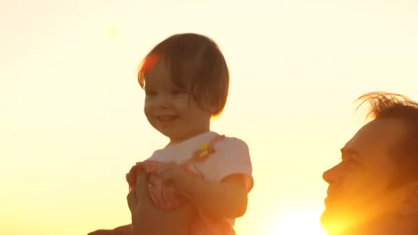 Baby tanzt und bricht in Gelächter aus, in den Händen des Papstes im goldenen Sonnenuntergang. — Stockvideo