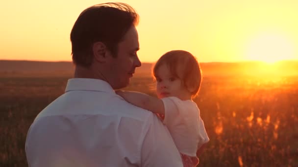 Ο πατέρας φέρνει το αγαπημένο παιδί του στα χέρια του το ηλιοβασίλεμα. Αργή κίνηση. — Αρχείο Βίντεο