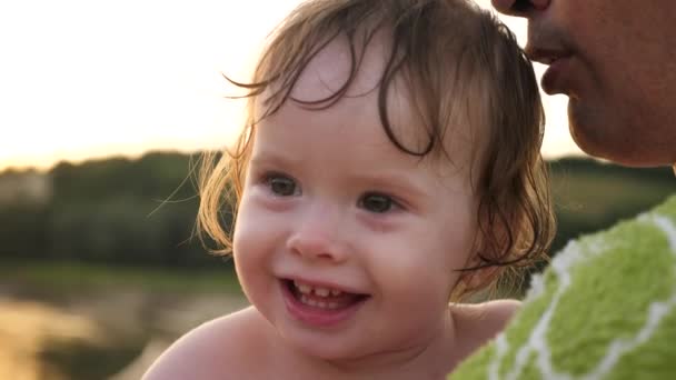 Pequeno bebê chora e ri caindo lágrimas enquanto sentado nas mãos do pai — Vídeo de Stock