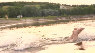 Mutlu kız mayo su altında dalışlar ve üzerinde yaz akşam gülüyor. Beach sezon. Ağır çekim