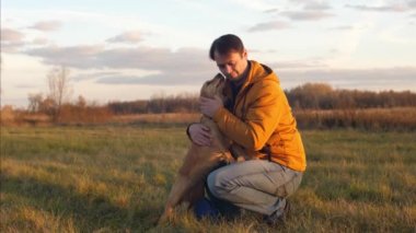 Adam onun en sevdiğim kırmızı köpek başını okşayarak ve parkta yürüyüş için gülümseyen