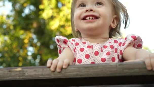 Little happy baby smiling with first baby teeth playing in park on bokeh background — Stock Video