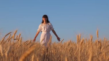 mutlu olgun buğday alanında, mavi gökyüzü, beyaz bir elbiseyle dans kız yavaş hareket