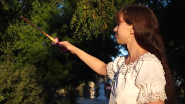 Mädchen lässt große Blasen im Stadtpark und lächelt. Zeitlupe — Stockvideo