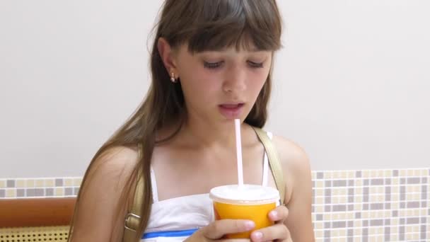 Menina bonita está sentada à mesa no café e beber coquetel e sorrindo — Vídeo de Stock