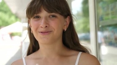 Kız gülümseyerek ve konuşmayı City'deki tüp kokteyl içiyor. Yakın çekim.