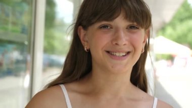 Kız öğleden sonra ve gülümser tüp vitrin City suyu içer. Yakın çekim