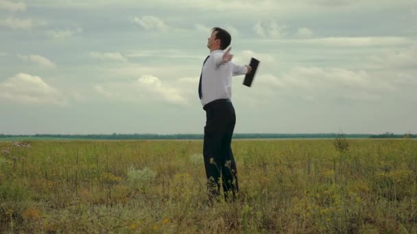 Агроном в белой рубашке и галстуке с портфелем в руке кружится в полете на фоне темных облаков — стоковое видео
