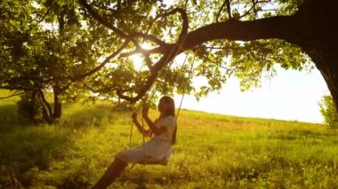 Mutlu kız golden sunset ve gülümseyen parlak ışınları hızıyla üzerinde sallanan uzun saçlı. Ağır çekim