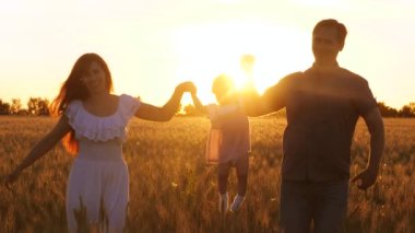 Annem ve babam mutlu çocuk bebek güler kollarından, at. Mutlu aile çocuk anne ve baba bir alanda gün batımı ışınları buğday ile yürüyüş.
