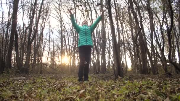 Menina adolescente joga folhas de outono para cima. Movimento lento . — Vídeo de Stock