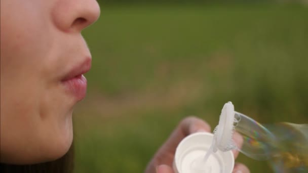 Mulher bonita soprando bolhas de sabão transparentes e sorrindo. Movimento lento — Vídeo de Stock