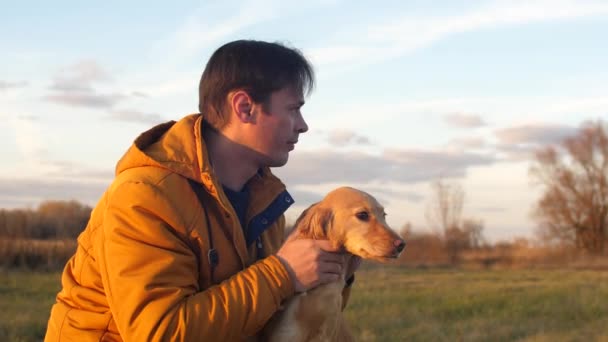 Sahibi köpek eliyle okşayarak, insan sonbahar parkta köpek yürüme — Stok video