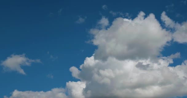 Big white cumulus clouds fly in the blue sky, time-lapse — Stock Video