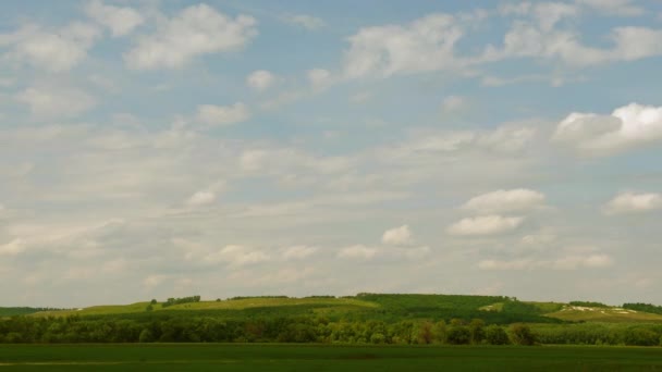 Sur les collines verdoyantes, des cumulus blancs volent dans le ciel bleu. intervalle de temps 
