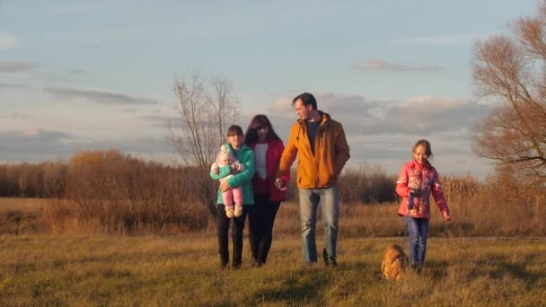 Ehepaar geht mit Kindern im Herbstfeld spazieren. — Stockvideo