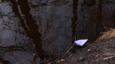 Beyaz kağıt gemi sahile kadar o taşır geçerli yüzüyor.