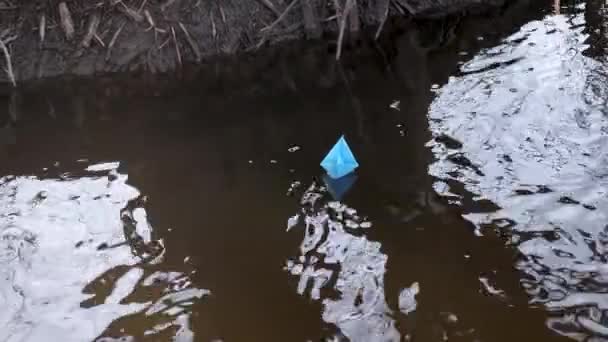 Blått papper båt av färgat papper flyter längs hösten stream. — Stockvideo