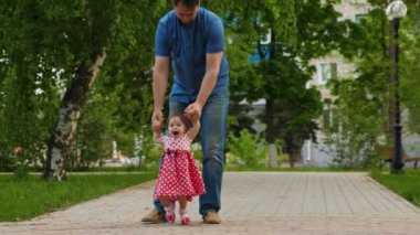 Baba küçük bebek Parkı giderken yol açar. Çocuk yürümeyi öğrenir. Anne-baba ile Çocuk yolda