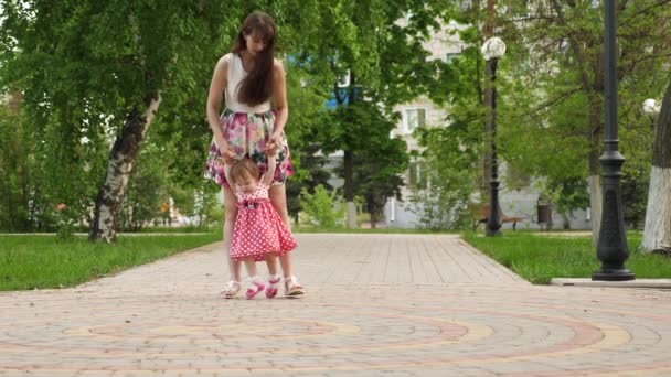 妈妈在去公园的路上领着小宝宝 孩子学会走路 与孩子一起散步的父母 — 图库视频影像