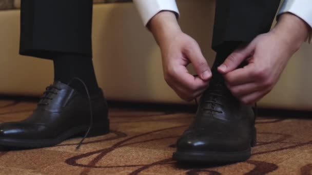 Hombre ata sus cordones en sus zapatos negros — Vídeo de stock