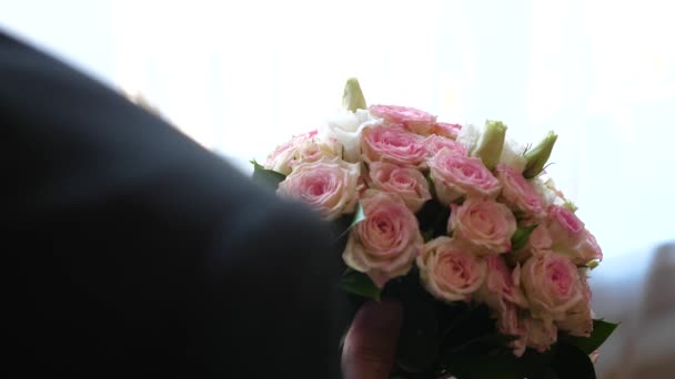 Bukett av mångfärgade rosor i händerna på en man. — Stockvideo