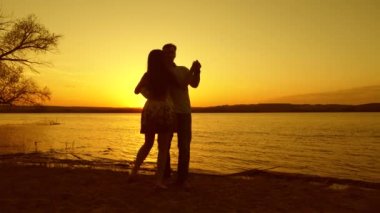 Gün batımında sahilde dans mutlu çift. Sahilde aşık çift romantik akşam.