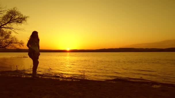 Wesoła dziewczyna szczęśliwy taniec na plaży o zachodzie słońca — Wideo stockowe